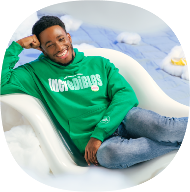 Smiling-man-wearing-a-green-Incredibles-brand-sweatshirt-and-lounging